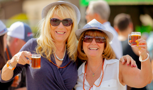 Two women holding their drinks up