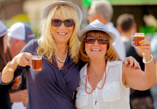 Two women holding their drinks up