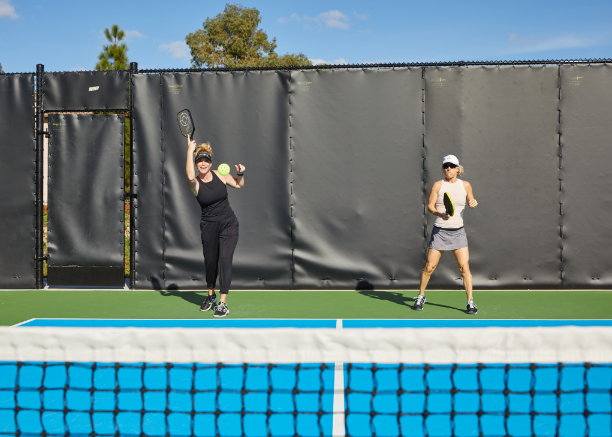 Two women on a court playing pickleball