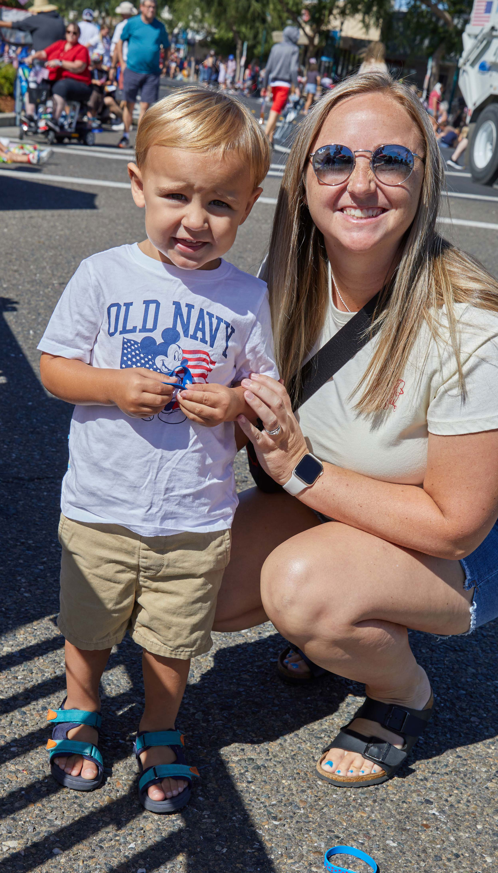Mom and son smiling at the camera at the July 4th parade