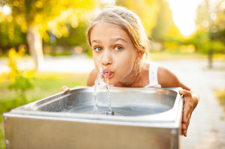 Girl drinking water at a fountain