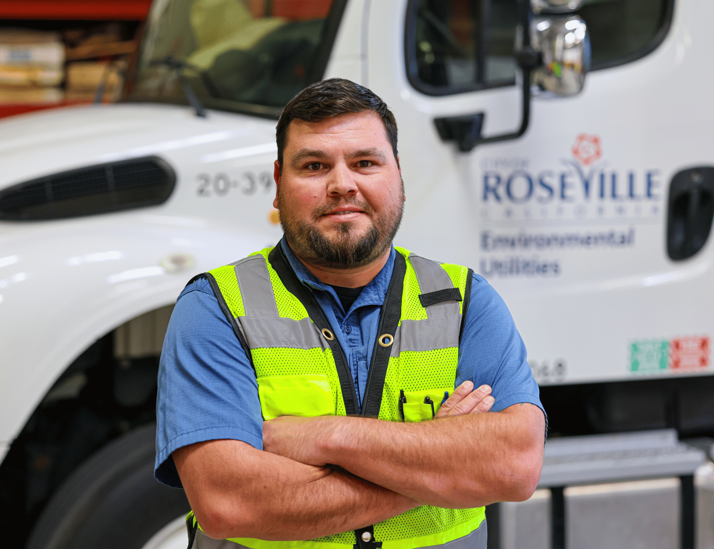 Anthony - A man in a bright neon safety vest stands with arms crossed in front of a white service van labeled “Roseville,” with the van door and side panel visible behind him