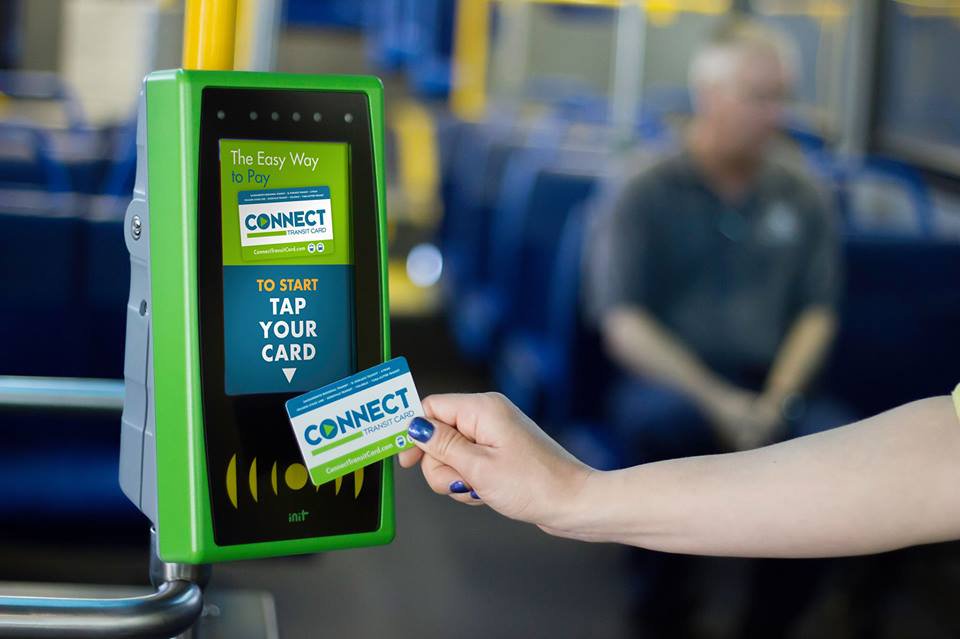 A rider taps their Connect card on an on-board device. 